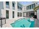 Backyard pool with outdoor kitchen and a modern home exterior featuring swan floats and palm trees at 5917 Cat Claw Ln, Bradenton, FL 34210