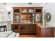 Stylish bar area featuring granite countertops, wine storage, and custom cabinetry with glass doors at 6352 W Maclaurin Dr, Tampa, FL 33647