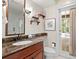 Bathroom featuring a marble countertop, wooden vanity, and a door leading to the outdoor scenery at 6352 W Maclaurin Dr, Tampa, FL 33647