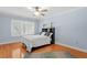 Spacious bedroom with hardwood floors, a ceiling fan, and large windows at 6352 W Maclaurin Dr, Tampa, FL 33647