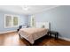 Bright bedroom features hardwood floors, a ceiling fan, and windows with plantation shutters at 6352 W Maclaurin Dr, Tampa, FL 33647