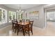 Bright dining room features a modern chandelier, natural light, and views of the lush green outdoors at 6352 W Maclaurin Dr, Tampa, FL 33647