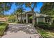 Beautiful home exterior with a circular driveway, arched entryway, and elegant landscaping at 6352 W Maclaurin Dr, Tampa, FL 33647