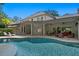 Rear exterior of home with large pool and covered patio, perfect for outdoor entertaining at 6352 W Maclaurin Dr, Tampa, FL 33647
