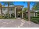 Elegant home with an arched entryway, meticulously maintained landscaping, and a grand facade at 6352 W Maclaurin Dr, Tampa, FL 33647