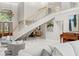 Bright foyer showcasing staircase, chandelier, and marble floors with open floorplan to dining and living area at 6352 W Maclaurin Dr, Tampa, FL 33647
