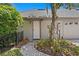 Inviting front entry with a brick walkway, mature landscaping, and a charming awning at 6352 W Maclaurin Dr, Tampa, FL 33647