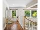 Upstairs hallway with hardwood floors and a pair of wicker chairs next to a mirror at 6352 W Maclaurin Dr, Tampa, FL 33647