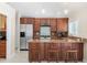 Stylish kitchen featuring wood cabinetry, stainless steel appliances, and bar seating for casual dining at 6352 W Maclaurin Dr, Tampa, FL 33647