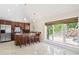 Open kitchen area with wooden cabinets, stainless steel appliances, and a breakfast bar overlooking the pool at 6352 W Maclaurin Dr, Tampa, FL 33647