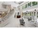Bright and airy living room featuring a staircase, large windows, and stylish furnishings at 6352 W Maclaurin Dr, Tampa, FL 33647