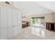 Bright living room with white tile flooring, views of the pool, and access to the kitchen at 6352 W Maclaurin Dr, Tampa, FL 33647
