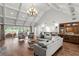 Bright living room with high ceilings, hardwood floors, a bar area, and access to outdoor patio at 6352 W Maclaurin Dr, Tampa, FL 33647