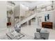 Open-concept living room featuring a staircase, high ceilings, and modern decor at 6352 W Maclaurin Dr, Tampa, FL 33647