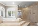 Luxurious bathroom with soaking tub on raised platform and glass-enclosed shower at 6352 W Maclaurin Dr, Tampa, FL 33647