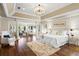 Spacious main bedroom with hardwood floors, sitting area, tray ceiling, and a luxurious chandelier at 6352 W Maclaurin Dr, Tampa, FL 33647
