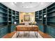 Elegant home office with a custom curved wall of teal bookshelves and a rustic wood desk at 6352 W Maclaurin Dr, Tampa, FL 33647