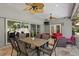 Covered patio with ceiling fans, dining area, and comfortable seating overlooking the backyard pool at 6352 W Maclaurin Dr, Tampa, FL 33647