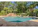 Backyard pool with in-pool umbrella, waterfall feature, and well-maintained landscaping at 6352 W Maclaurin Dr, Tampa, FL 33647