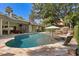 Beautiful backyard pool featuring a rock waterfall, in-pool umbrella, and poolside seating at 6352 W Maclaurin Dr, Tampa, FL 33647