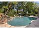 Backyard pool featuring a waterfall and in-pool seating area under an umbrella at 6352 W Maclaurin Dr, Tampa, FL 33647
