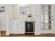 This wet bar features white cabinets, a beverage refrigerator, and a white countertop at 6352 W Maclaurin Dr, Tampa, FL 33647