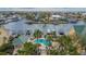 An aerial view features palm trees surrounding a pool with boat docks on a canal, offering resort-style living at 6414 Sunset Bay Cir, Apollo Beach, FL 33572