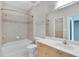 Bathroom with tiled shower-tub combination, light wood vanity, and large mirror at 6414 Sunset Bay Cir, Apollo Beach, FL 33572