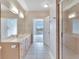 Bright bathroom featuring double sinks, a walk-in shower, and access to the bedroom at 6414 Sunset Bay Cir, Apollo Beach, FL 33572
