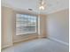 Carpeted bedroom featuring a large window with blinds and neutral paint at 6414 Sunset Bay Cir, Apollo Beach, FL 33572