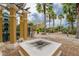 Picturesque courtyard with a fire pit, palm trees, and manicured landscape near the canal at 6414 Sunset Bay Cir, Apollo Beach, FL 33572