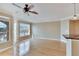 Open living space with hardwood floors, ceiling fan and balcony access at 6414 Sunset Bay Cir, Apollo Beach, FL 33572