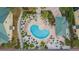 Aerial view of a Kidney-shaped pool surrounded by lush landscaping and lounge chairs, perfect for relaxation at 6414 Sunset Bay Cir, Apollo Beach, FL 33572