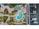Overhead angle shows a kidney-shaped pool with a pool-house, lounge chairs and boat docks nearby at 6414 Sunset Bay Cir, Apollo Beach, FL 33572