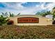 Exterior sign for Sunset Bay with lush landscaping and bright yellow facade at 6414 Sunset Bay Cir, Apollo Beach, FL 33572