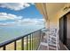 Balcony with a table and chairs overlooking beautiful water views on a sunny day at 7540 Sunshine Skyway S Ln # 217, St Petersburg, FL 33711