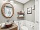Half bath featuring a unique vessel sink, wooden shelves, and decorative mirror at 7540 Sunshine Skyway S Ln # 217, St Petersburg, FL 33711