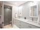 Bathroom featuring double sinks, modern fixtures, mosaic tile wall, and glass shower door at 7540 Sunshine Skyway S Ln # 217, St Petersburg, FL 33711