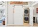 Convenient laundry area featuring a stackable washer and dryer with a sliding barn door entrance at 7540 Sunshine Skyway S Ln # 217, St Petersburg, FL 33711