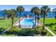 Community swimming pool with palm trees overlooking the water at 7540 Sunshine Skyway S Ln # 217, St Petersburg, FL 33711