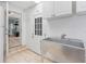 White utility room with stainless sink, tile flooring, and an exterior door at 7690 91St St, Seminole, FL 33777