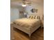 Cozy main bedroom featuring a queen bed, white furniture, and hardwood floors at 8320 112Th St # 206, Seminole, FL 33772