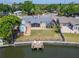 Aerial view of charming property with a backyard featuring a dock, colorful patio, and well-maintained lawn at 8702 Driftwood Dr, Tampa, FL 33615