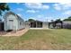 Sprawling backyard showcasing a utility shed, lake views and enclosed lanai at 8702 Driftwood Dr, Tampa, FL 33615