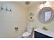 Charming powder room with coastal decor, modern vanity, and stylish round mirror at 8702 Driftwood Dr, Tampa, FL 33615