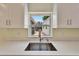 The kitchen has stone countertops, a stainless sink, and is bright from the window above at 8702 Driftwood Dr, Tampa, FL 33615