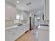 Well-lit galley kitchen featuring new stainless appliances, stone countertops and bright white cabinetry at 8702 Driftwood Dr, Tampa, FL 33615