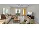 Bright living room featuring tile flooring, a comfy sofa, and a striking yellow front door at 8702 Driftwood Dr, Tampa, FL 33615