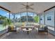Inviting sunroom with neutral furniture, ceiling fan, and view of the yard and waterfront at 8702 Driftwood Dr, Tampa, FL 33615
