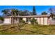 Charming one-story home with tropical landscaping and beige siding at 920 Palm Dr, Belleair Beach, FL 33786